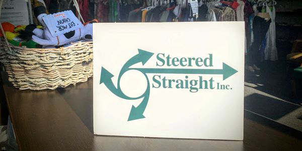 Steered Straight logo propped on table