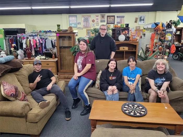 Group of people sitting on couches in thrift store
