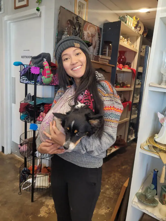 Young girl holding dog in thrift store
