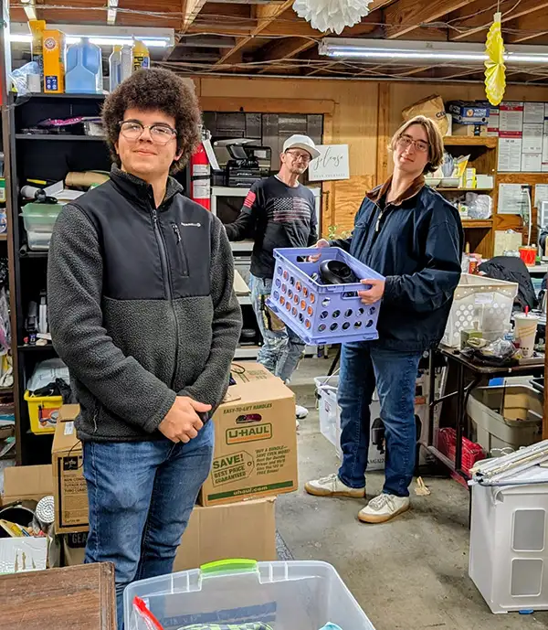 Three people organizing thrift store items