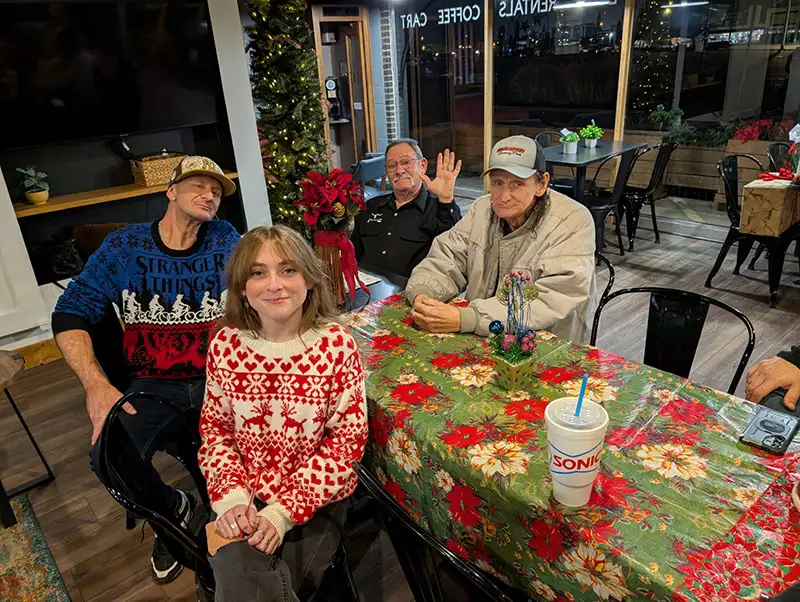 Four people at table with holiday tablecloth