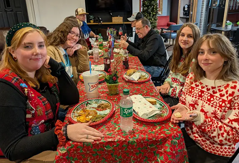 People sitting at party table with food
