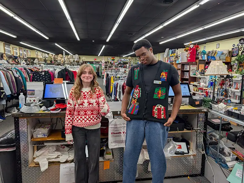 Two teens wearing holiday sweaters